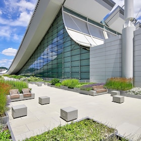 Rooftop amenity space at the David L. Lawrence Convention Center, featuring modern architecture, green planters, and paved seating areas.