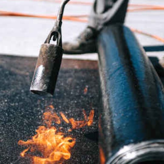 Contractor using torch to apply SMS Modified Bitumen