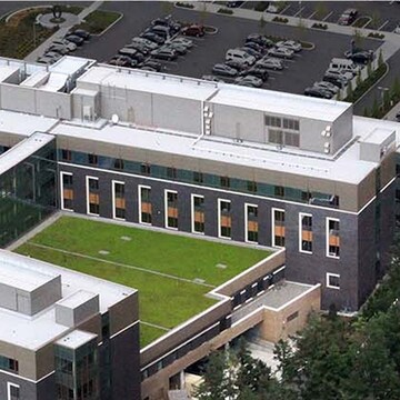 An aerial view of the modern Swedish Hospital complex with a mix of light-colored and green roofs, illustrating a large-scale commercial building project where Siplast roofing and waterproofing systems provide long-term protection and peace of mind for building owners.