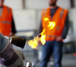 Contractor using torch to apply roofing materials